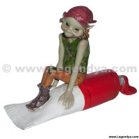 figurine de pixie sur tube de peinture rouge